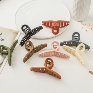 Détail de grandes pinces à cheveux mates en sept couleurs avec design élégant croisé