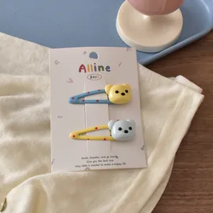Detail of cute bear-shaped hair clips with colorful dots on a soft knit background