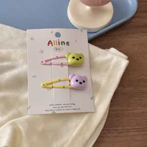 Detail showing two cute bear hair clips on card with pink and yellow dotted patterns