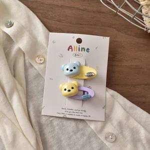 Close-up of cute resin bear hair clips in blue, yellow, and purple on display card