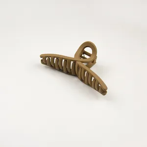 Detail view of large matte coffee-colored cross hair claw clip with sturdy spring mechanism