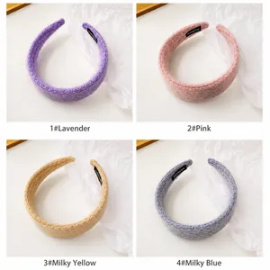 Detail view of four pastel knitted headbands featuring the handmade fabric label