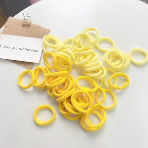 50-piece set of high-elasticity seamless yellow gradient hair ties on a white surface
