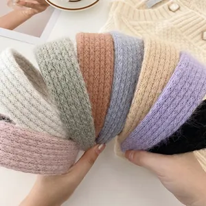 Handheld assortment of colorful soft mohair knitted headbands in eight autumn colors