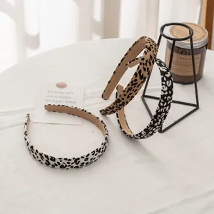 Tres diademas finas con estampado de leopardo sobre un fondo blanco con textura