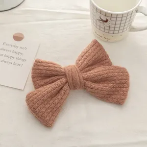 Close-up of a double-layered knitted mohair bow hair clip in clay pink with soft texture