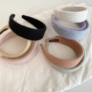Close-up of multi-colored knitted headbands featuring clear texture and handmade labels