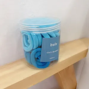 Close-up of blue gradient seamless elastic hair ties in a clear cylindrical jar