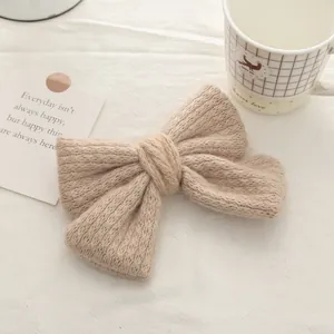 Close-up of beige knit double bow hair clip with textured mohair and vintage knitting