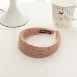 Detail of soft mohair knit headband in lotus root pink with a handmade woven label