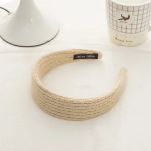 Detail of hand-made beige mohair knit headband showing thick woven texture and label