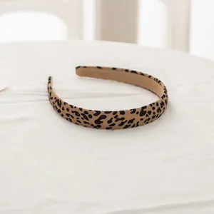 Detalle de la diadema con estampado de leopardo y textura de tela sobre fondo blanco