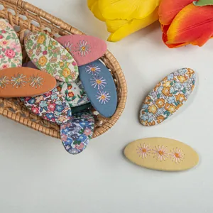 Détail de barrettes à cheveux en tissu avec broderies florales de style champêtre