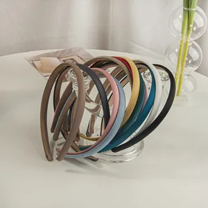 Collection of colorful minimalist satin headbands in earthy tones on a stylish glass display