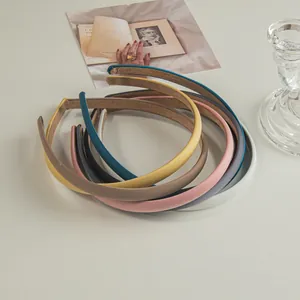Detailed view of six colorful slim headbands with smooth faux leather texture