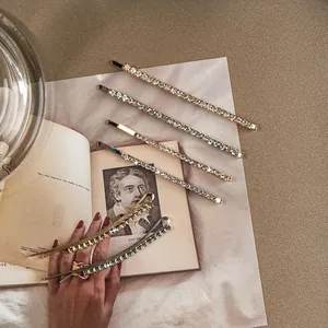 Eleganti fermagli per capelli con strass in oro e argento su pagine di libri vintage