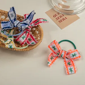 Lot de quatre chouchous à nœuds à carreaux avec broderie d'étoiles sur fond beige