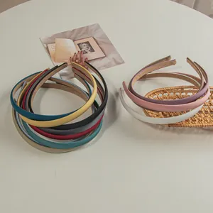 Detail of colorful matte thin headbands showing non-slip suede lining on a white table