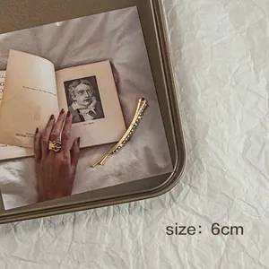 Dettaglio di un fermaglio per capelli dorato da 6cm con stelle su un libro