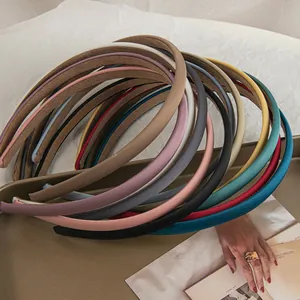 Close-up of colorful satin headbands neatly arranged in a metal tray on magazine