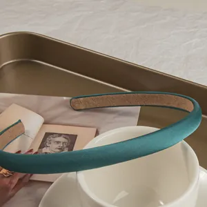 Detail of teal satin headband showing the anti-slip inner lining on a vintage tray