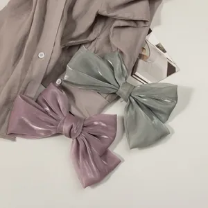 Gros plan de barrettes à cheveux en satin nacré élégantes en vert sauge et rose poudré