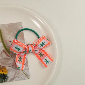 Macro d'un chouchou à carreaux orange avec bordure en dentelle et broderie d'étoile
