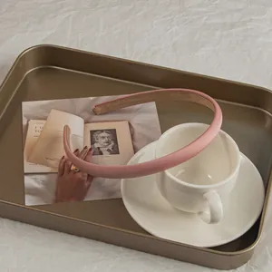 Detail of light pink frosted headband showing non-slip lining and smooth refined edges