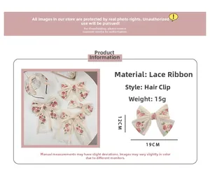 Detailed view of cream mesh ribbon hair clip with delicate pink rose embroidery detail
