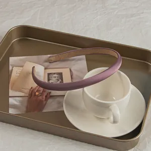 Close-up of a purple satin padded headband on a vintage tray with a coffee cup