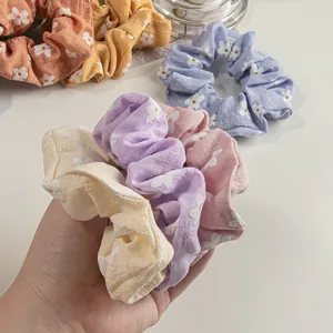 Schicke Blumen-Haargummis mit Gänseblümchen-Muster in verschiedenen Pastellfarben