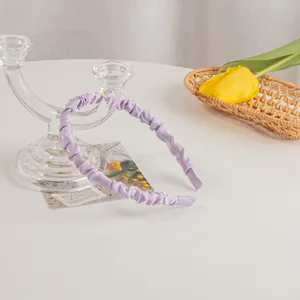 Detail of lavender pleated satin headband with smooth inner frame and protective ends