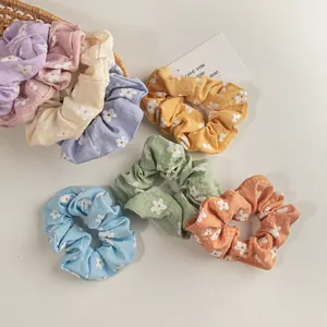 Set aus Haargummis mit Blumenmuster in verschiedenen Pastellfarben und Gänseblümchen