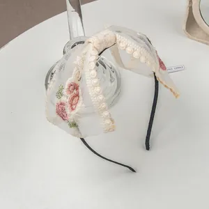 Detailed embroidery of pink flowers on a white mesh bow lace hair clip and headband