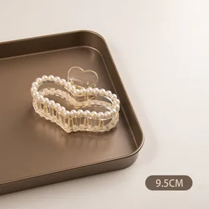 Détail de la pince à cheveux cœur 9,5cm avec bordure en perles et design transparent