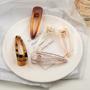 Close-up of five colorful resin hair clips in tortoiseshell and pastel translucent finishes