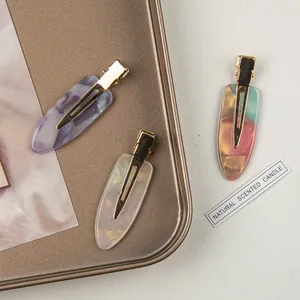 Three acetate marble hair clips with gold metal base in purple, white and pastel colors