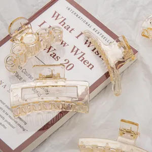 Detailed view of amber transparent acrylic hair claws on book background