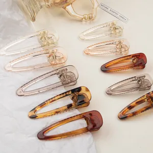 Detail shot of hollow triangular resin hair clips in amber and tortoiseshell finishes