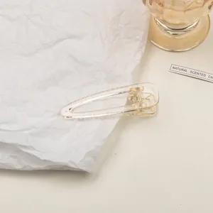 Detailed close-up of a clear acrylic hollow teardrop hair clip with metal spring