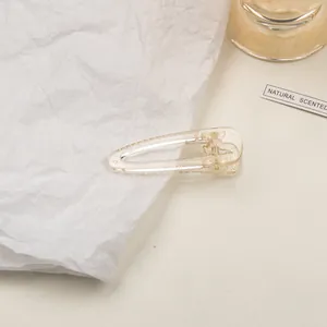 Close-up of a minimalist clear champagne acrylic duckbill hair clip with non-slip teeth