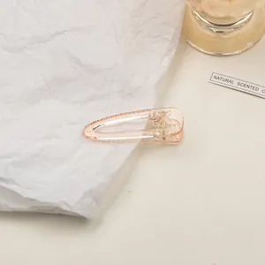 Detailed close-up of a peach transparent acrylic hair clip with a sturdy metal spring