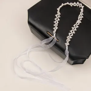 Detailed close-up of woven pearl mesh hairband with elegant white organza ribbons