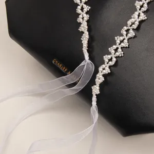 Elegant pearl bead hair ribbon necklace with white organza bow on a luxury leather bag