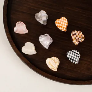 Mini heart acetate hair claws in various colorful marble and checkerboard patterns