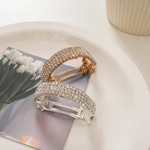 Sparkling rhinestone curved spring hair clips in gold and silver finish set on a white tray