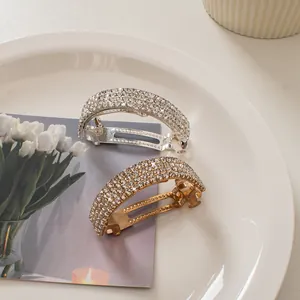 Close-up of gold and silver curved spring hair clips with rhinestone embellishments