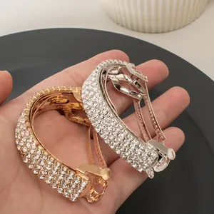 Close-up of gold and silver curved spring clips with sparkling rhinestones for hair