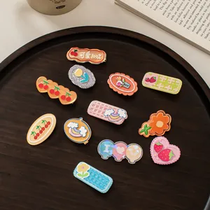 Bunte Acryl-Haarklammern Set mit Blumen- und Kirschmotiven in einer Holzschale