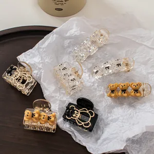 Detail shot of a 6-piece champagne bear hair clip set featuring resin and gold metal accents